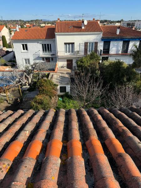 Réparation de tuiles fissurées à Perpignan : Application d’une bande de plomb plissé rouge et résine imperméabilisante pour une toiture étanche et durable.