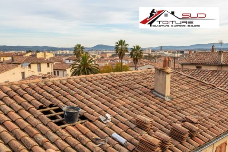 Travaux de réparation de toiture à Perpignan sur une maison typique du Roussillon avec tuiles canal et outillage de couvreur.